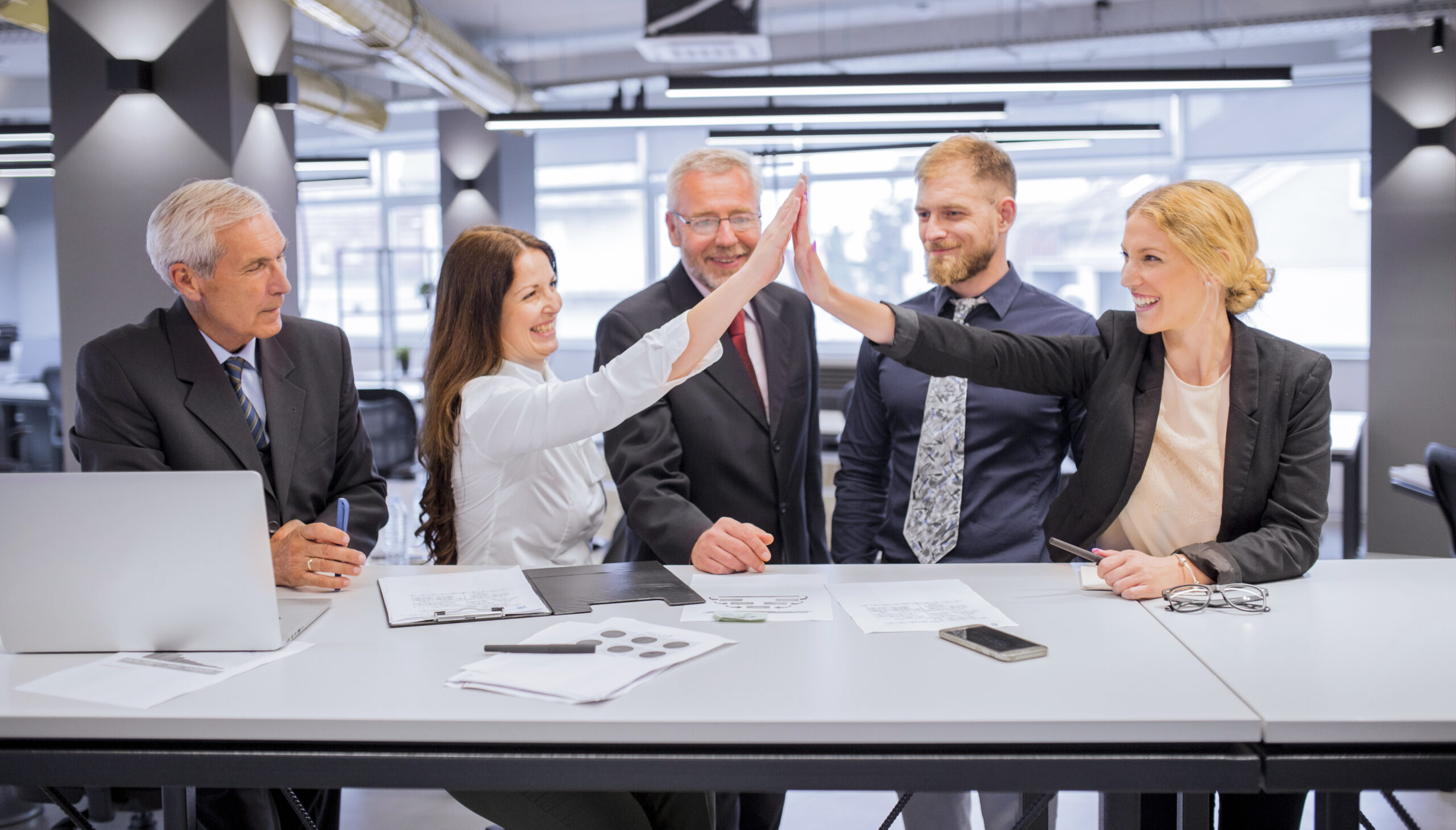 smiling-two-young-women-giving-each-other-high-five-office